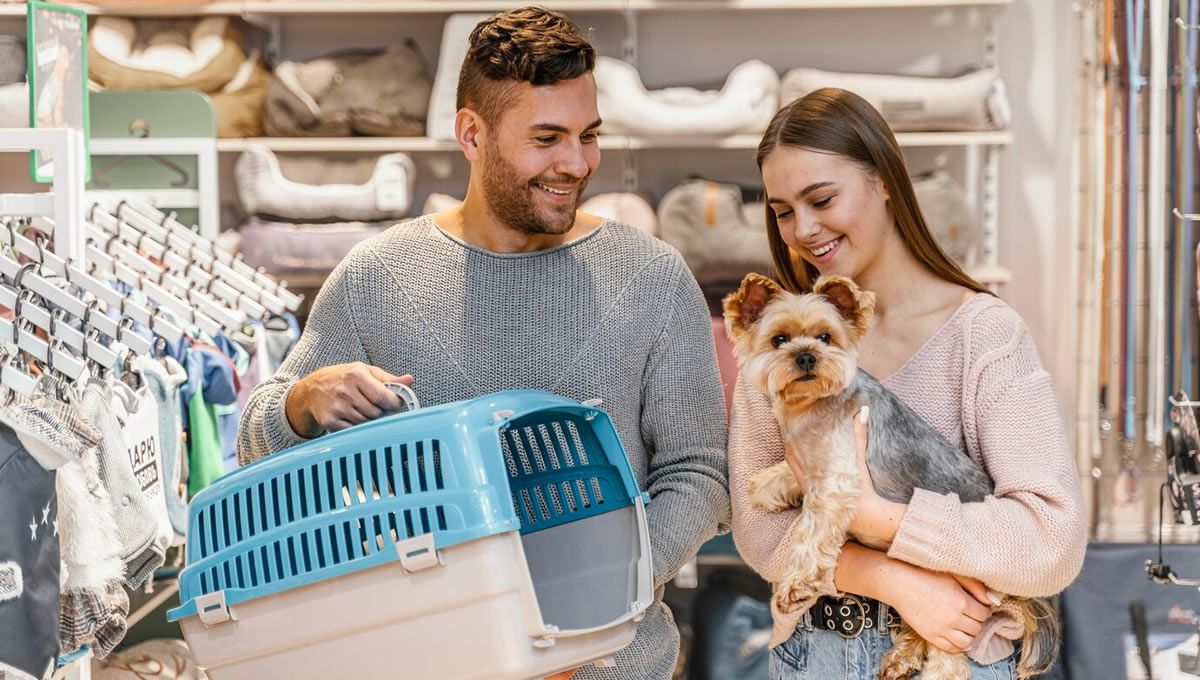 Una pareja en una tienda viendo los precios de un transportín para su perro. (Foto: Freepik)