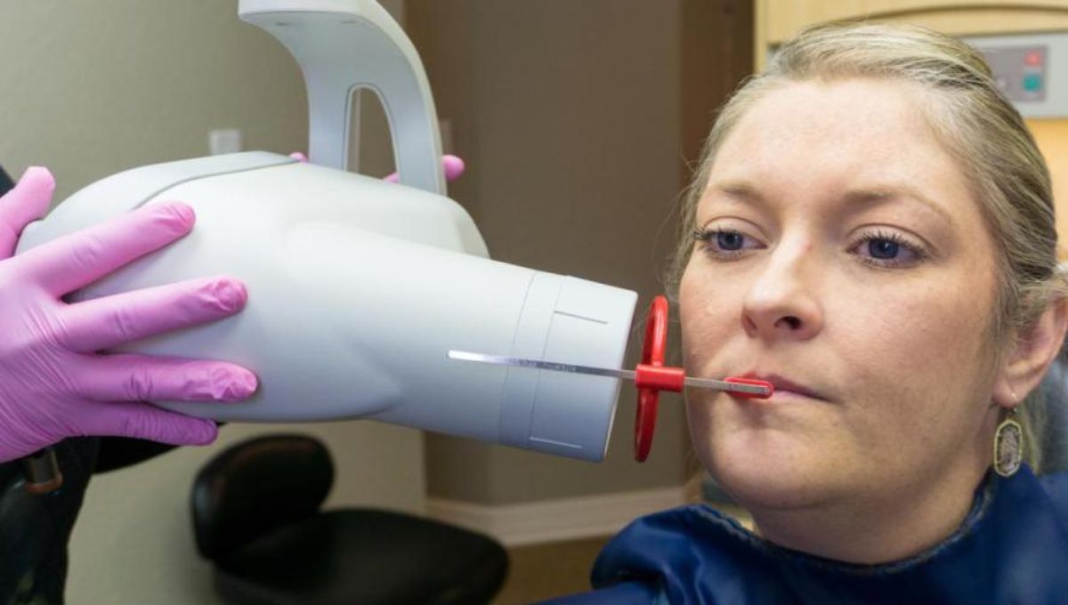 Mujer sometiéndose a una radiografia dental Fuente University TUFTS