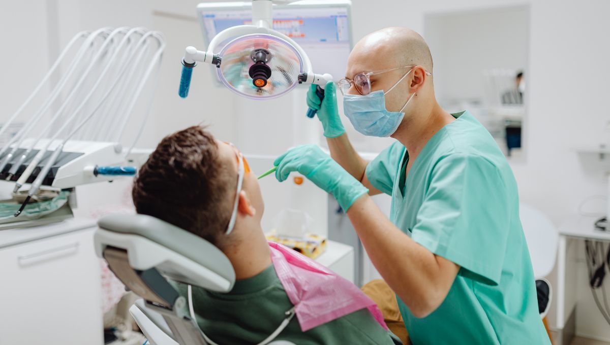 Dentista atendiendo a un paciente en la consulta dental Fuente Canva