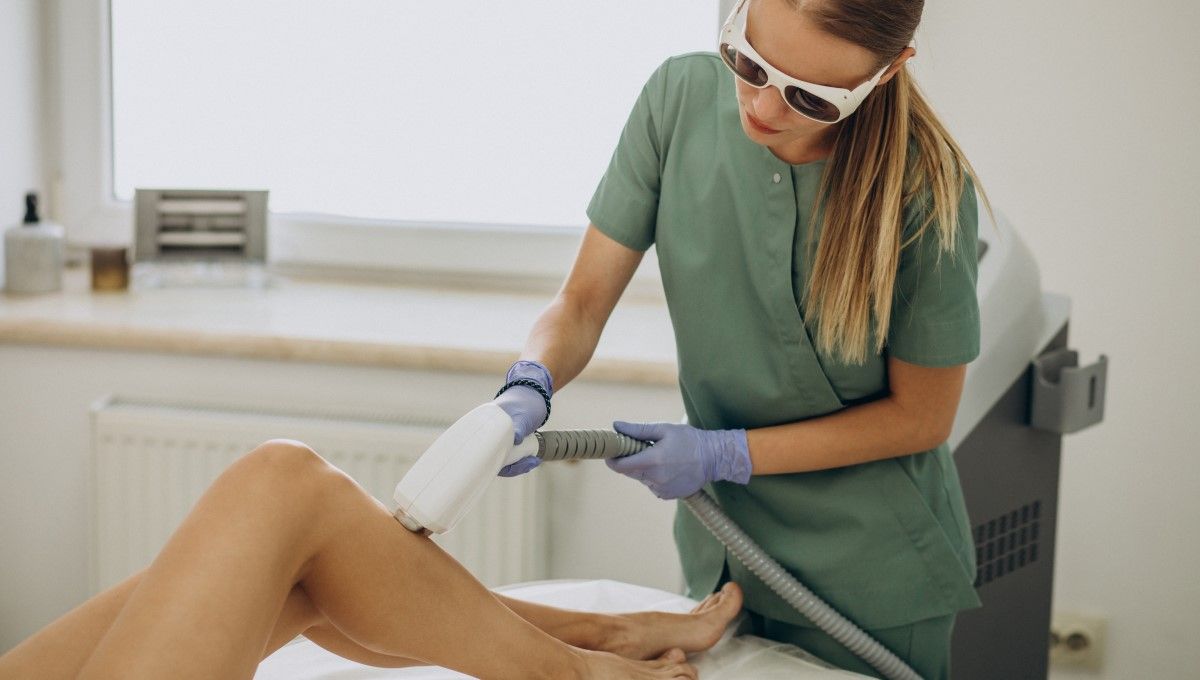 Profesional realizando la depilación láser en las piernas de una mujer (Foto. Freepik)