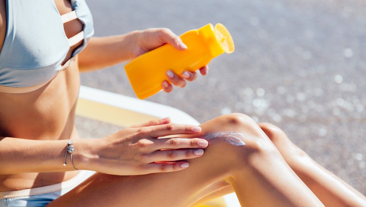Mujer aplicando crema solar en sus piernas (Foto. Freepik)