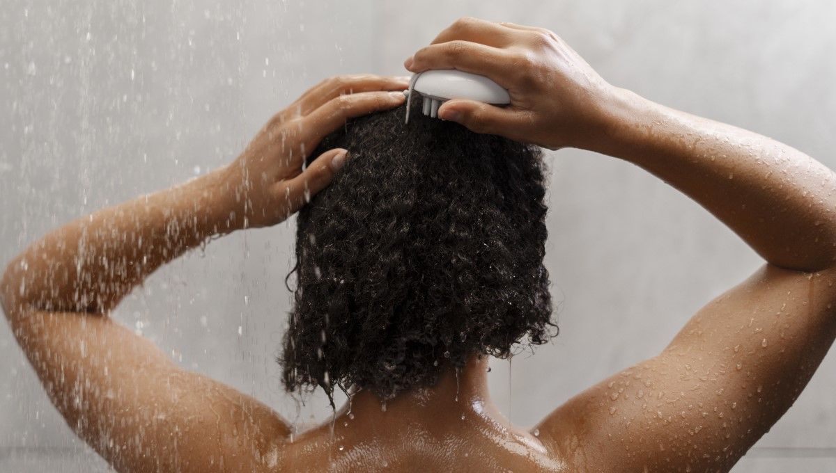 Mujer de pelo rizado dando un masaje en su cuero cabelludo (Foto. Freepik)