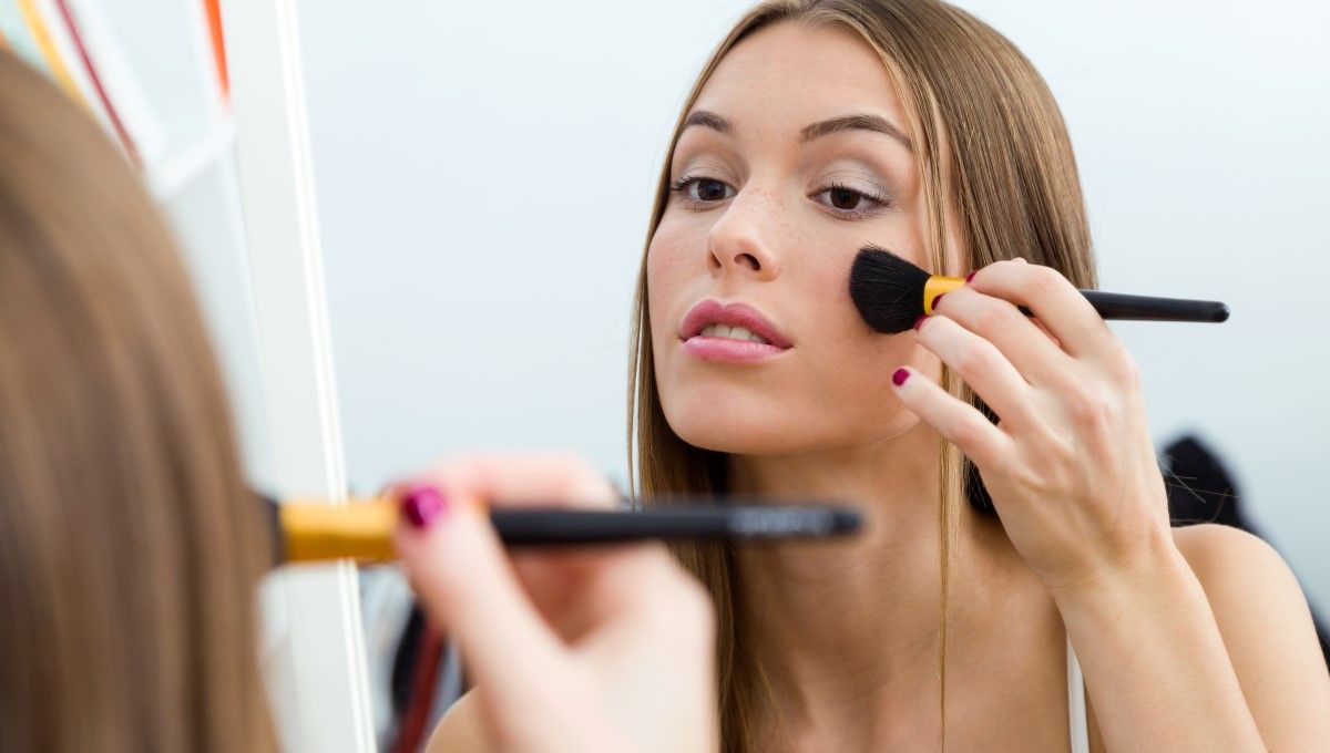 Mujer maquillando su rostro frente al espejo (Foto. Freepik)