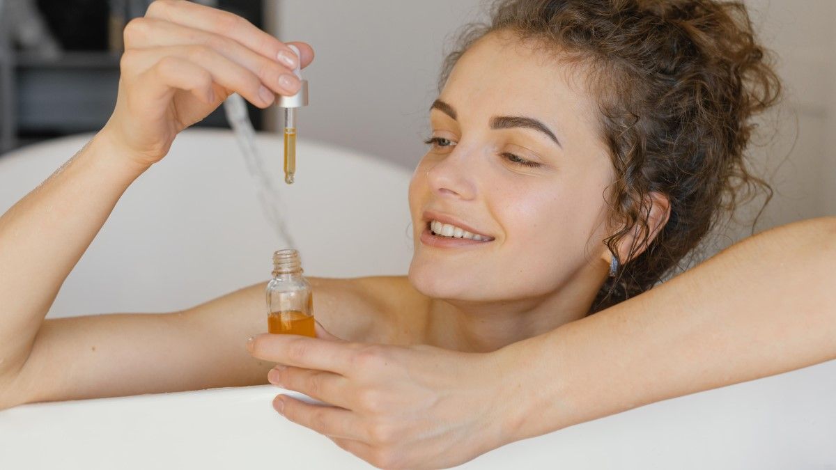 Mujer usando un aceite facial (Foto. Freepik)