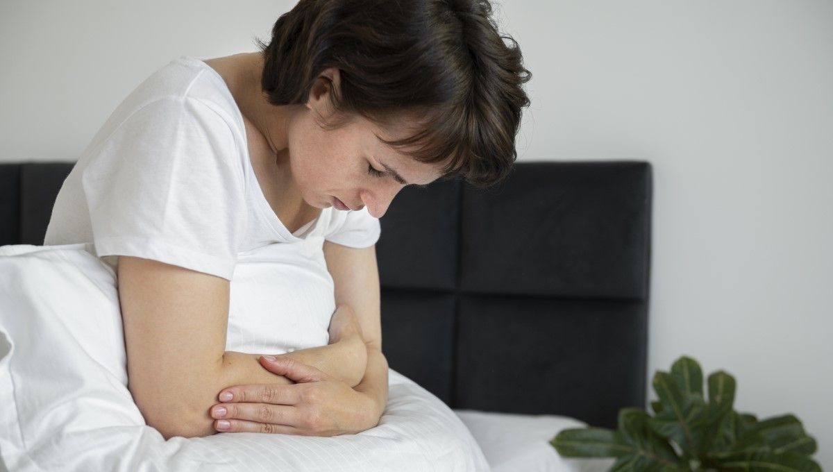 Mujer con dolor abdominal sentada en la cama (Foto. Freepik)