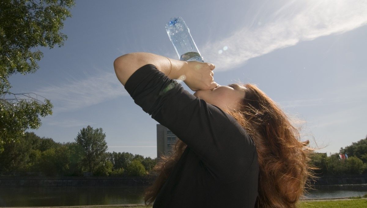 Mujer bebiendo agua durante una ola de calor (Foto. Freepik)