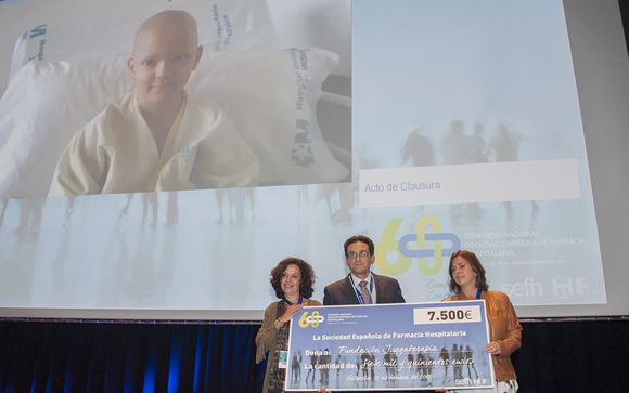 José Luis Poveda, presidente de SEFH, entrega la donación a miembros de Juegaterapia
